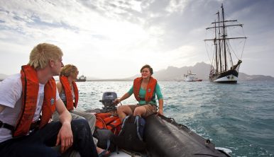 Trainees in a dinghy with Tall Ship Oosterschelde in the background